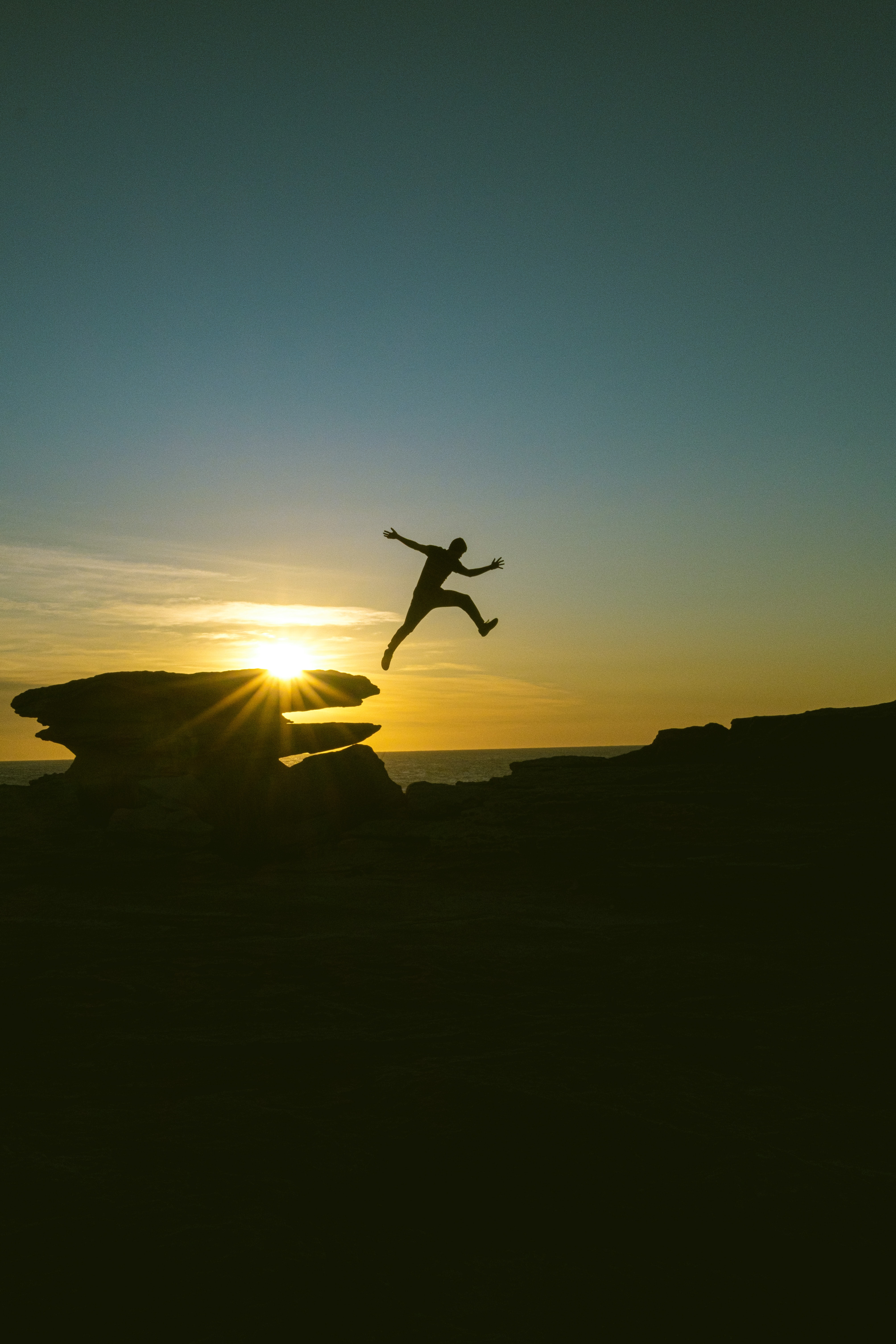 person, human, dark, sunset, rocks, bounce, jump wallpapers for tablet