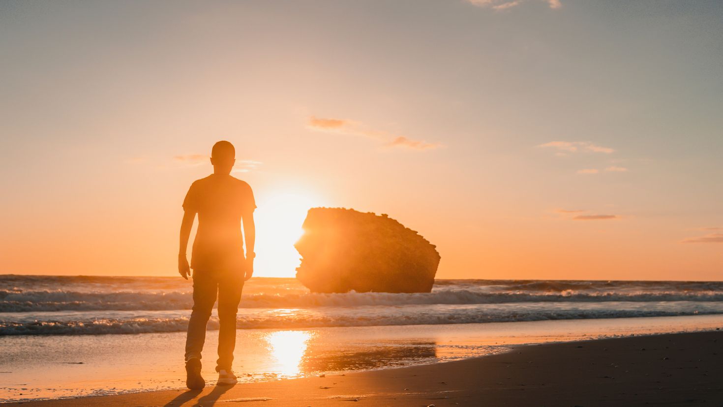 Мужчина в костюме на пляже на закате