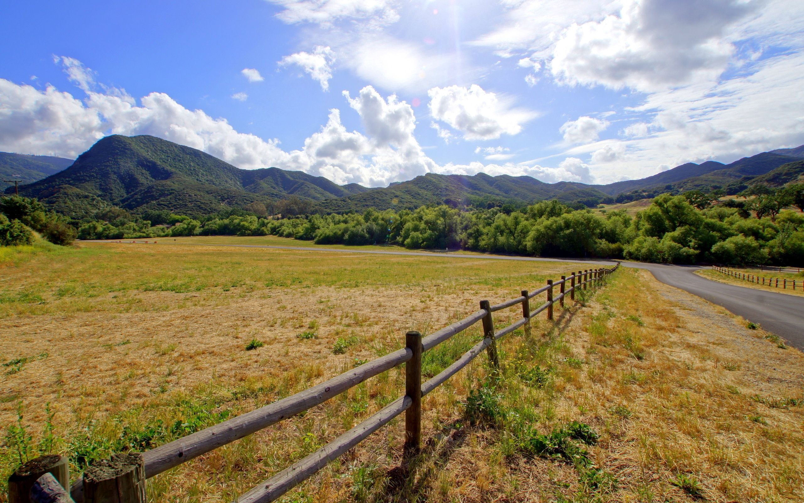 noon, clouds, nature, mountains, sun, shine, light, road, fencing, enclosure