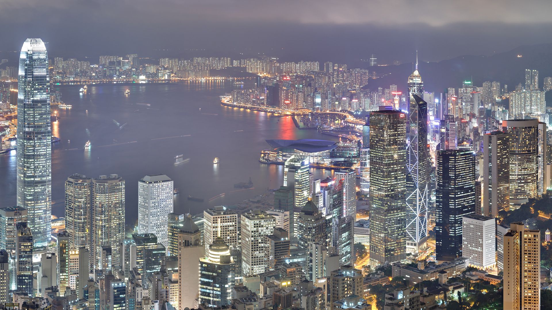 Скачать картинку Здания, Гонконг, Города, Небоскребы, Ночь, Свет в телефон бесплатно.