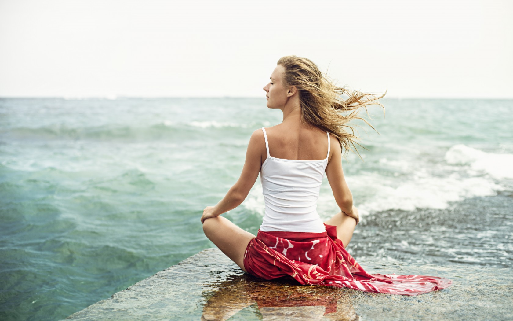 Девушка медитирует на море