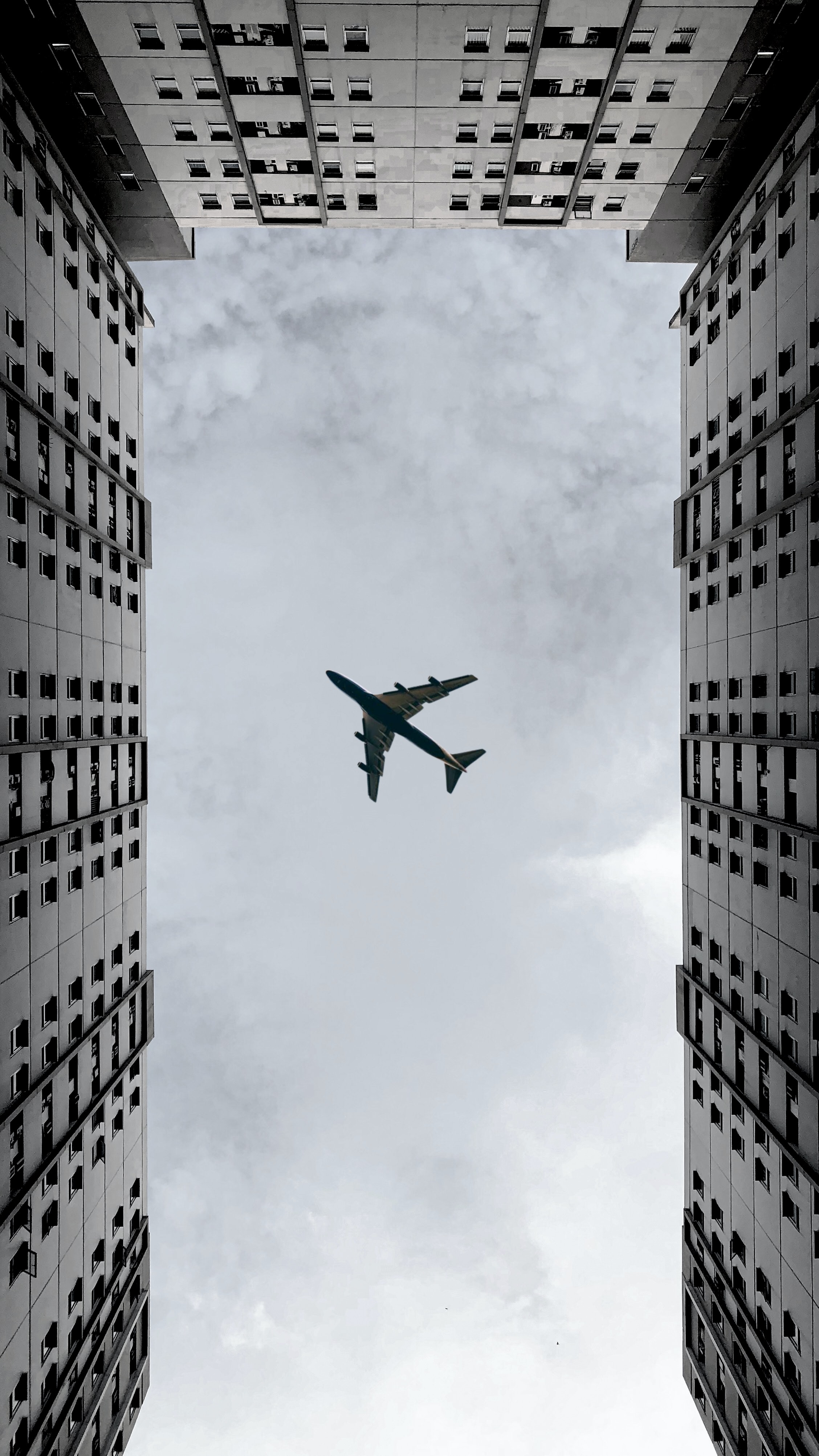 grey, plane, clouds, building, miscellanea, miscellaneous, airplane, bottom view Full HD