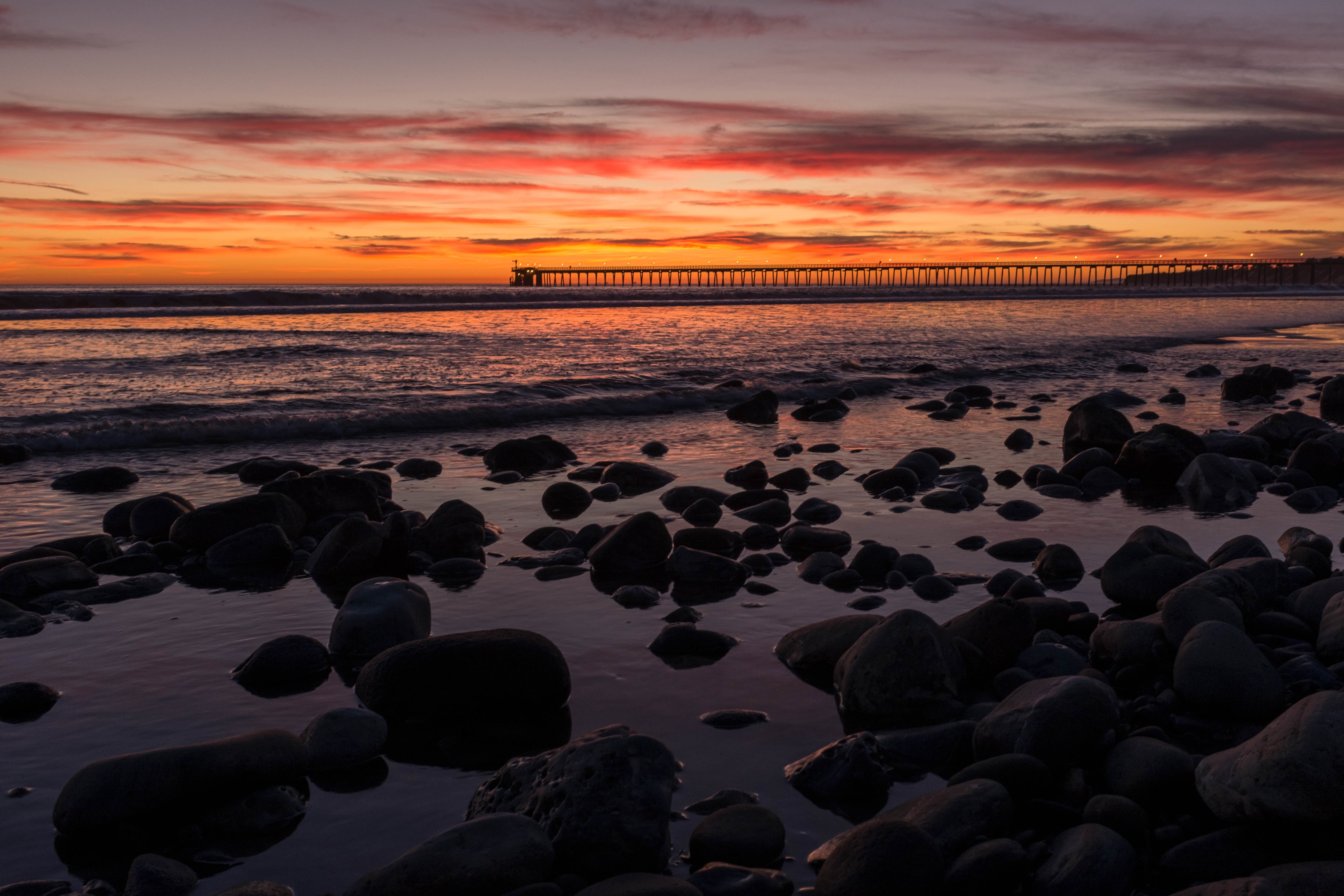 Download mobile wallpaper Sunset, Bridge, Horizon, Sea, Nature, Stones for free.