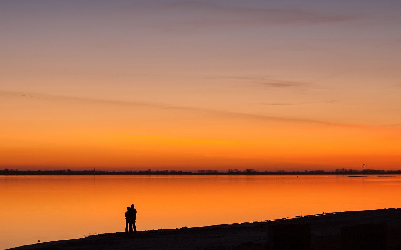 Download mobile wallpaper Shore, Bank, Lake, Sunset, Silhouettes, Nature, Pair, Couple, Romance for free.