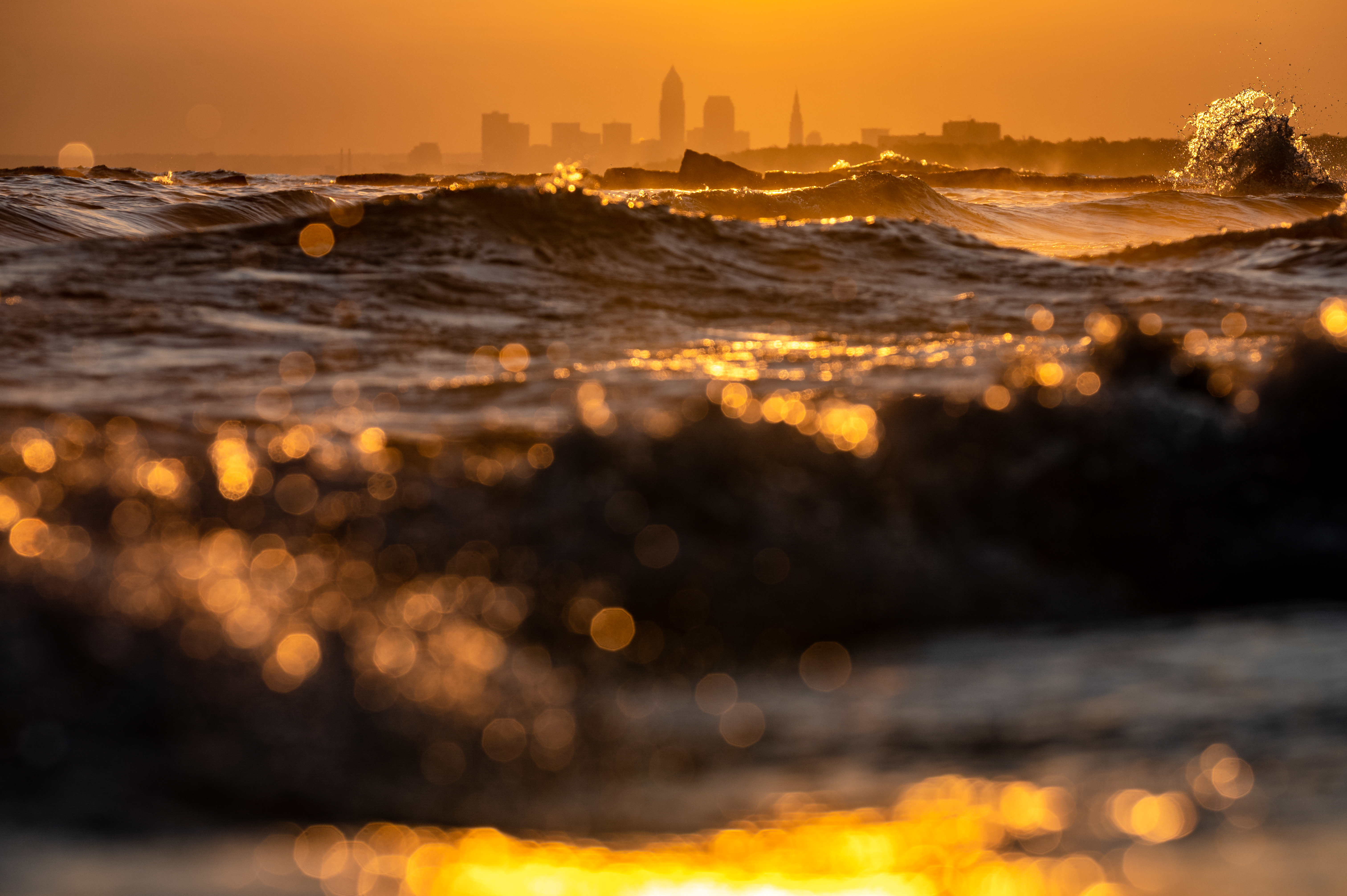 Download mobile wallpaper Miscellanea, Waves, Miscellaneous, Sunset, City, Building, Silhouettes for free.