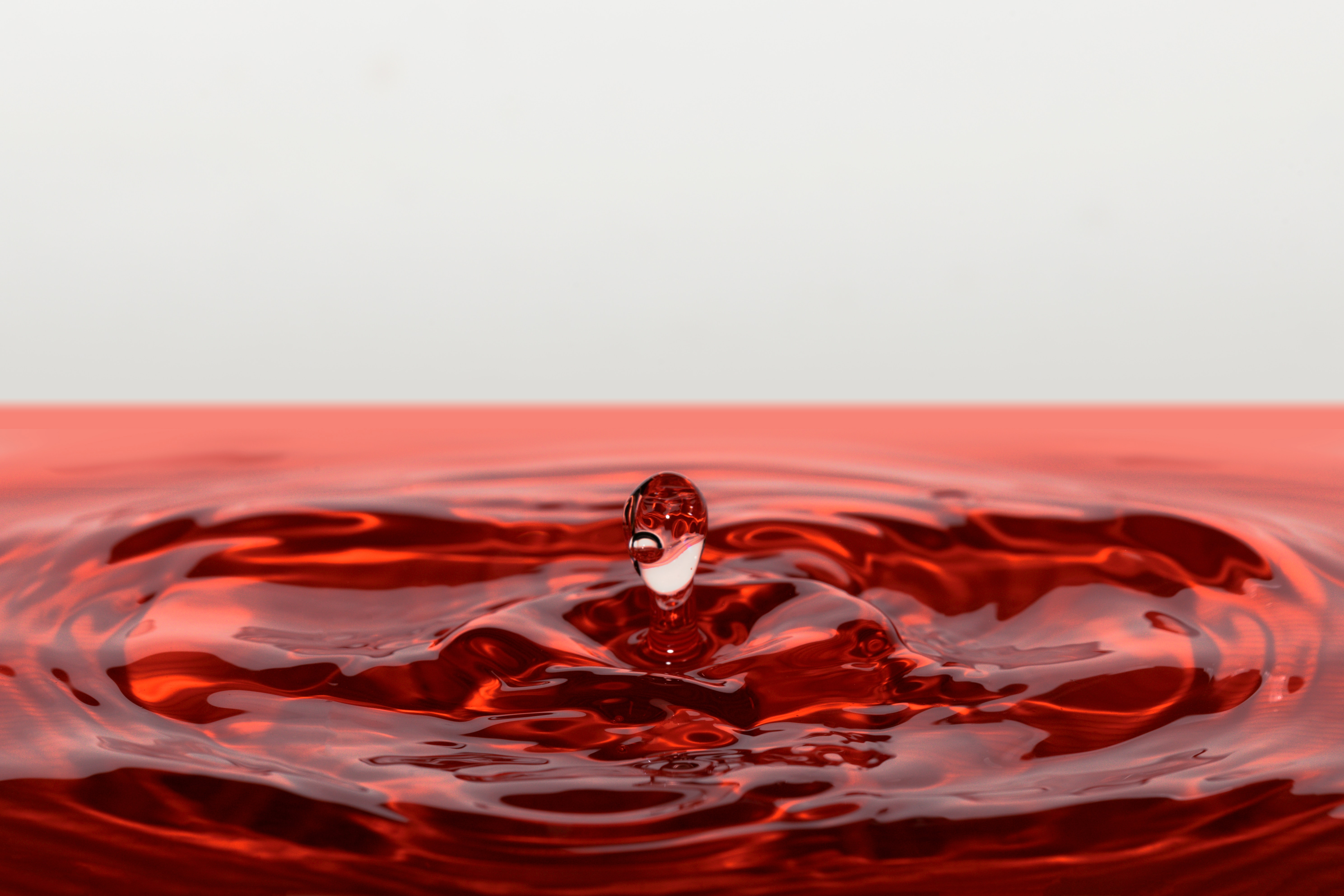 Кровь капает в воду. Капля. Капли воды. Красные капли. Разлитая вода.