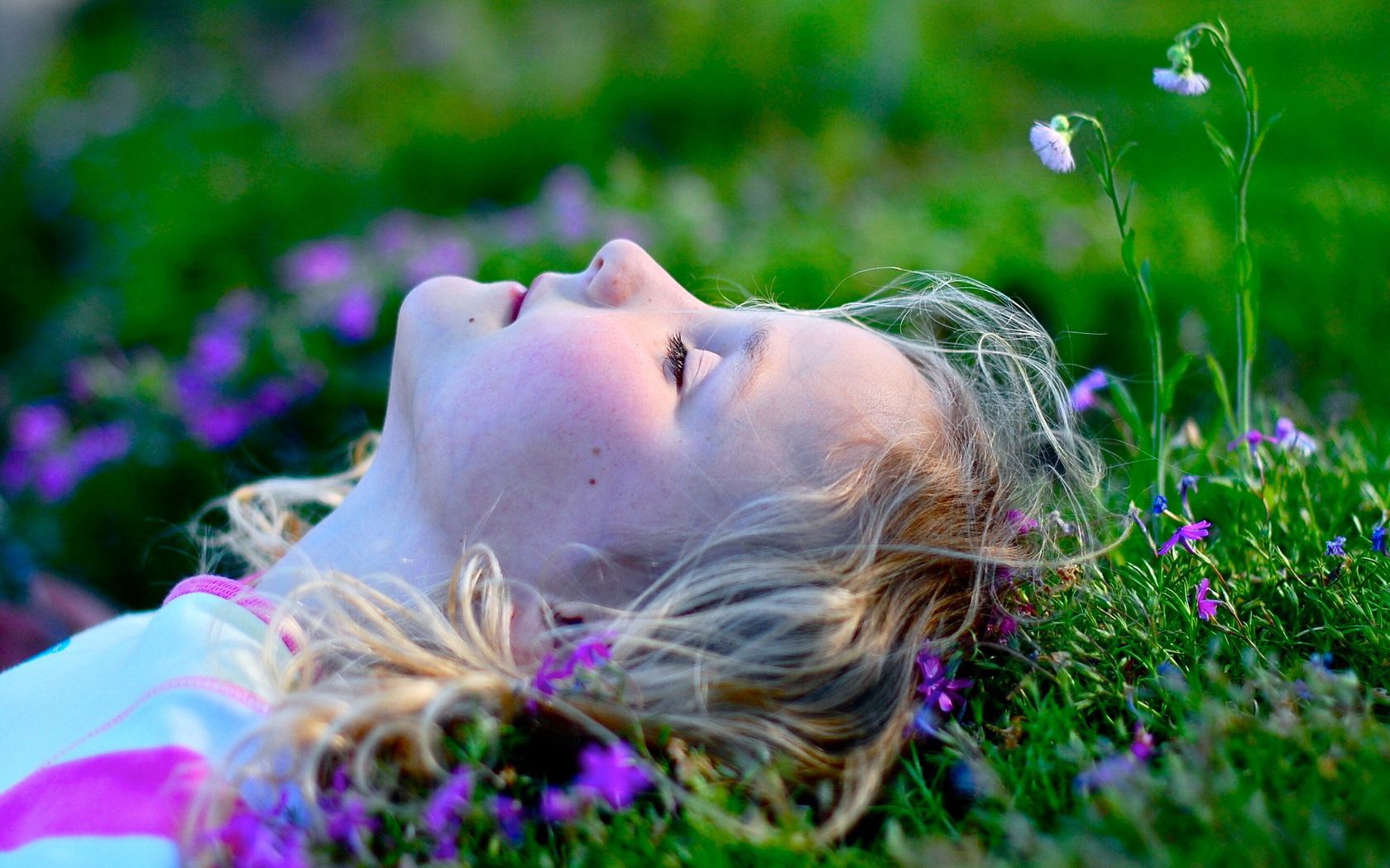 Девочка лежит на траве