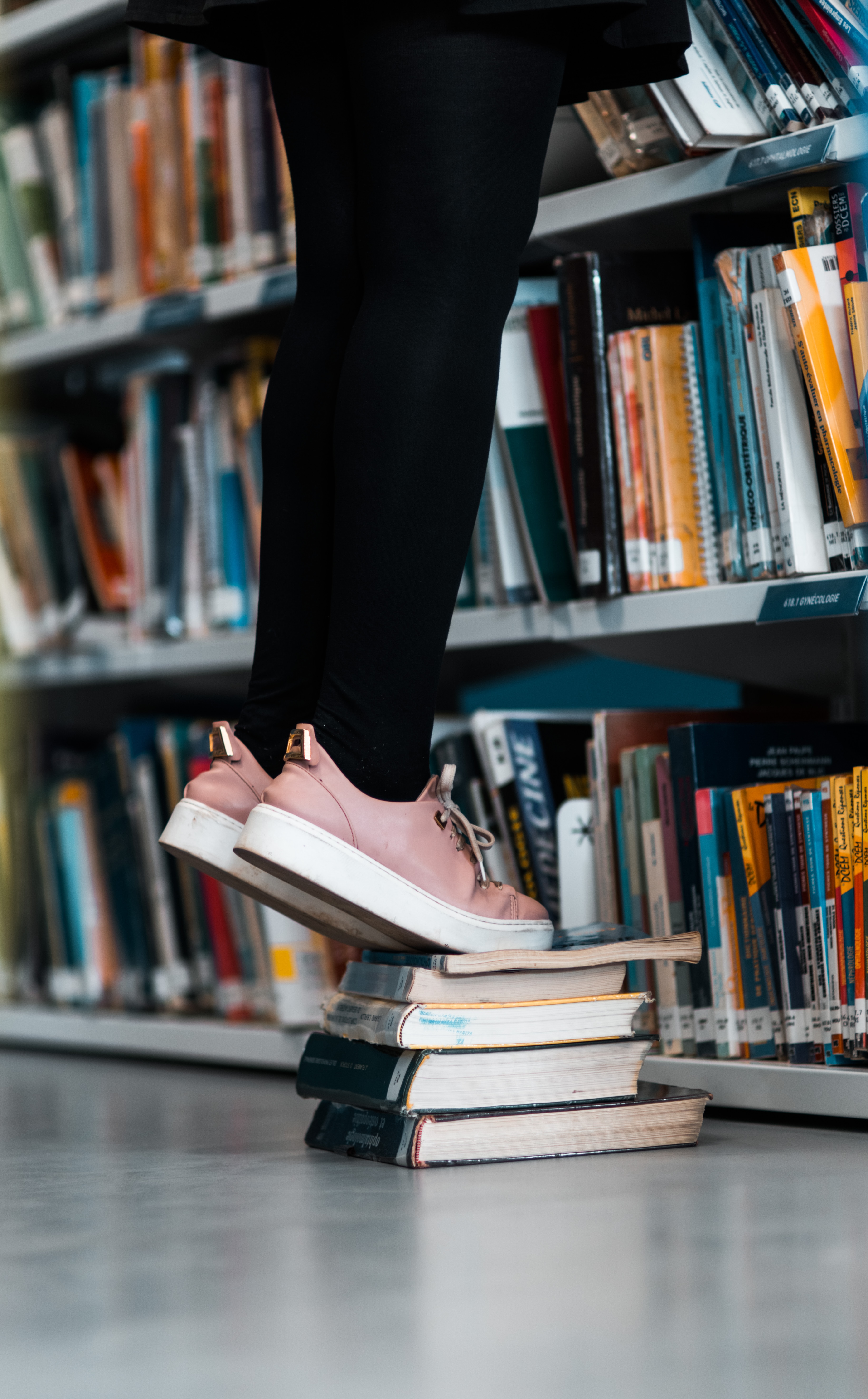 Download mobile wallpaper Miscellaneous, Bookshelves, Miscellanea, Legs, Sneakers, Library, Books for free.