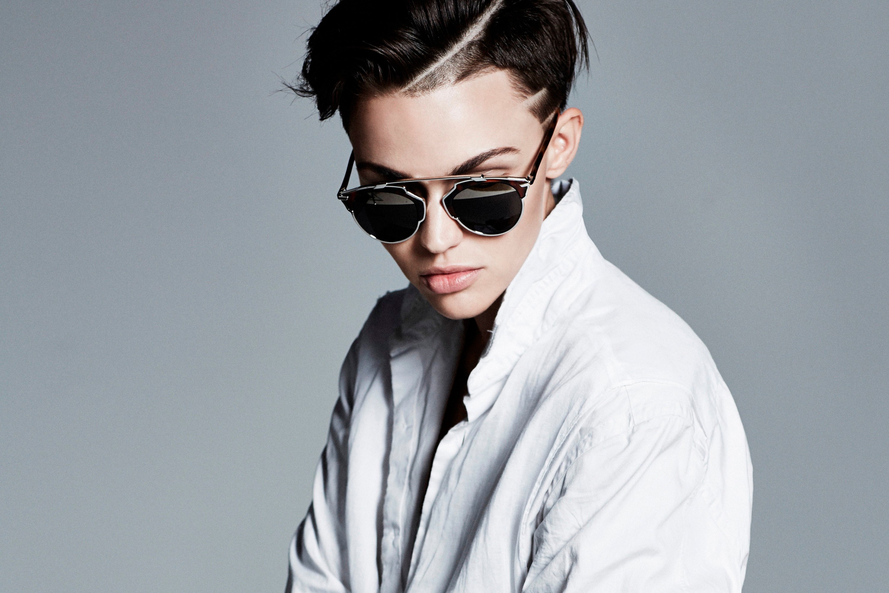 Portrait Of Young Woman With Short Hair And Round Sunglasses .