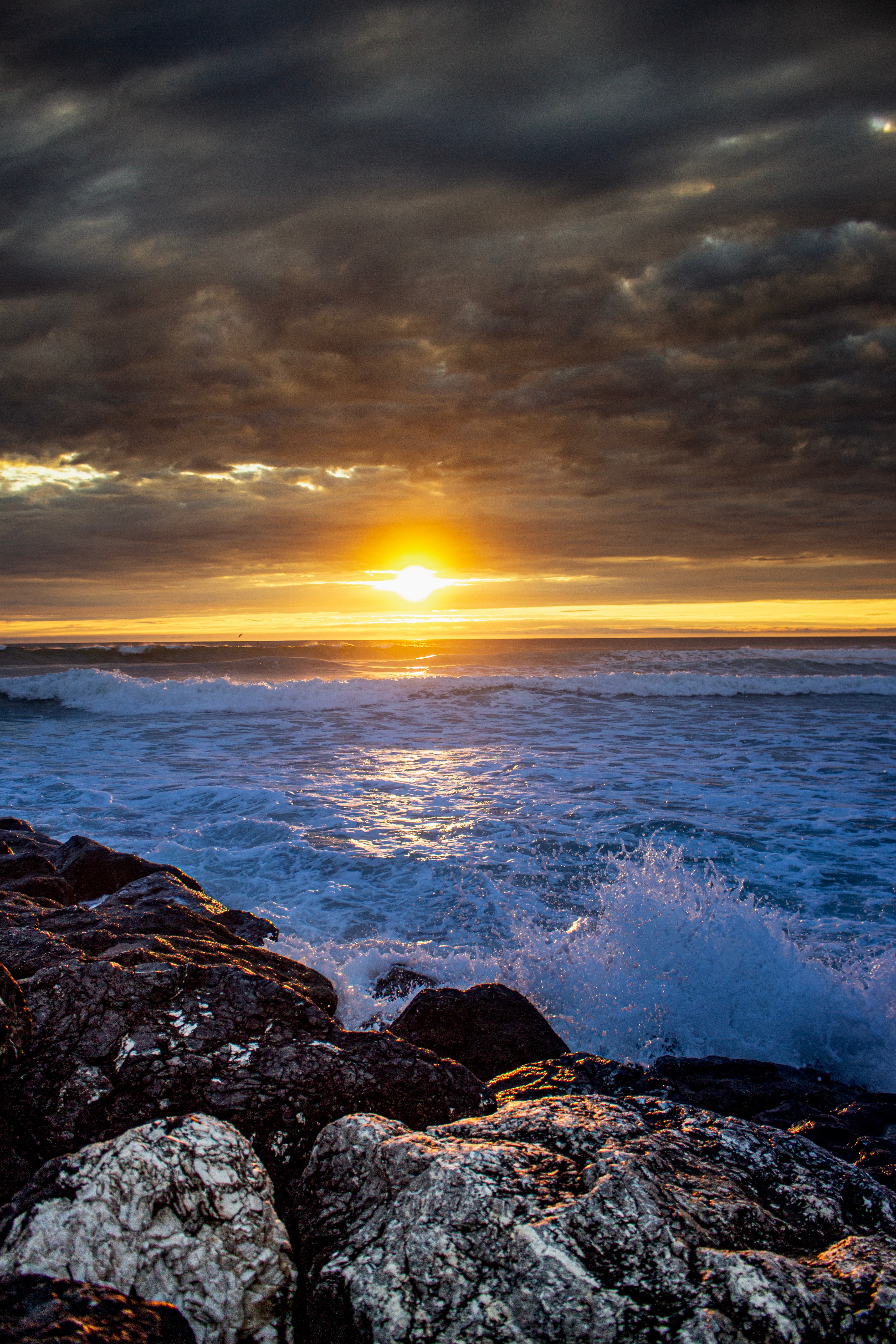 140277 Hintergrundbild herunterladen natur, sunset, sea, waves, felsen, die steine, sprühen, spray - Bildschirmschoner und Bilder kostenlos