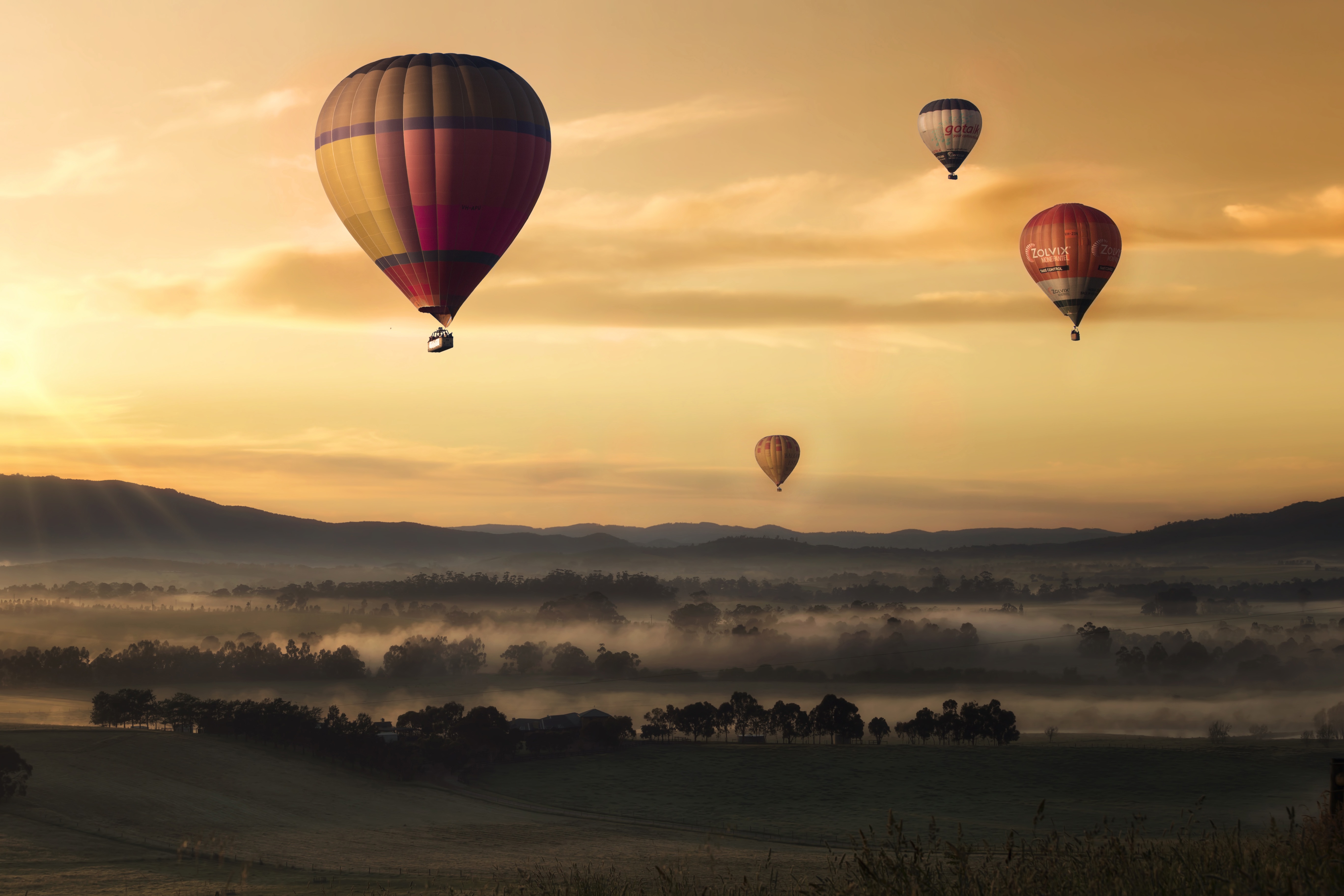Download mobile wallpaper Fog, Field, Sky, Sunset, Nature, Balloons for free.