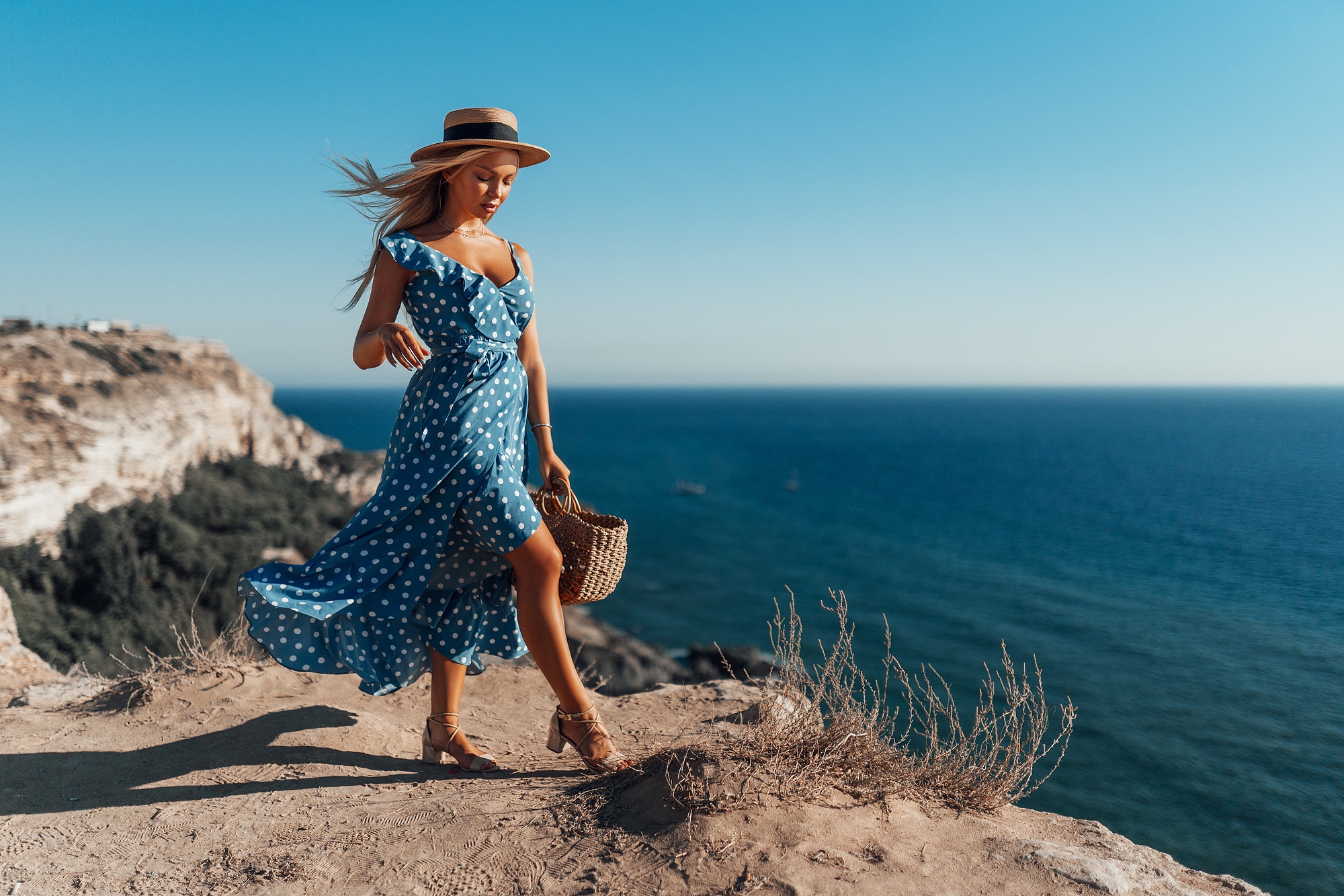 Девушка в платье и шляпе на берегу моря