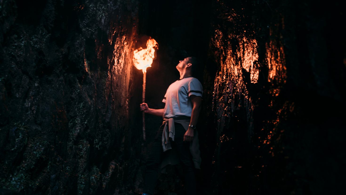 Горел как факел мужское. Человек с факелом в пещере. Человек факел. Человек с факелом в темноте. Мужик с факелом.