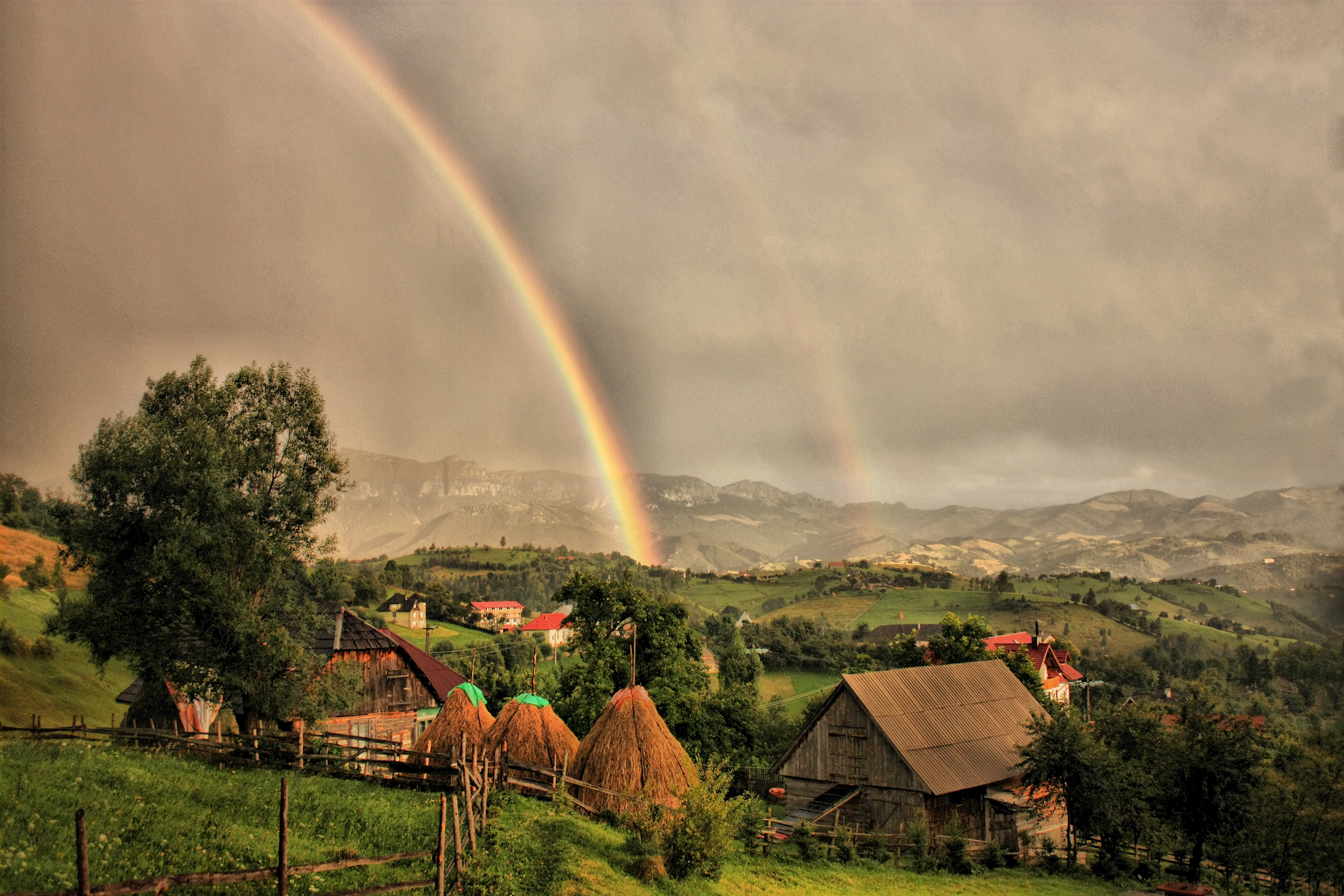 Download mobile wallpaper Clouds, Rainbow, Nature, Houses, Landscape for free.