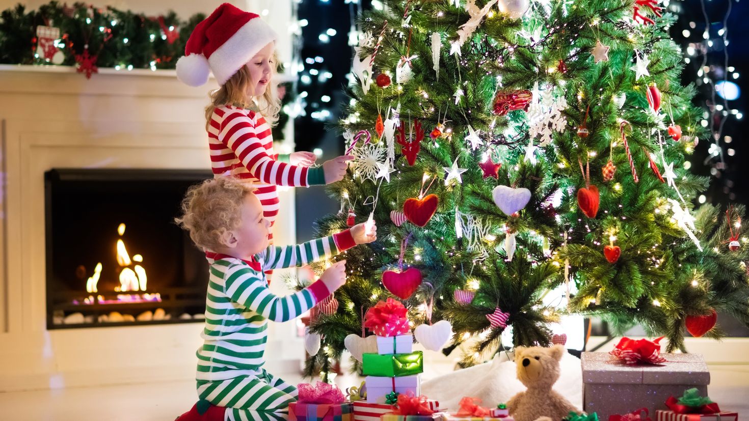 Рождественские елки для детей. Елка Новогодняя украшенная. Подарки для елки. Дети наряжают елку. Красивая елка с подарками.