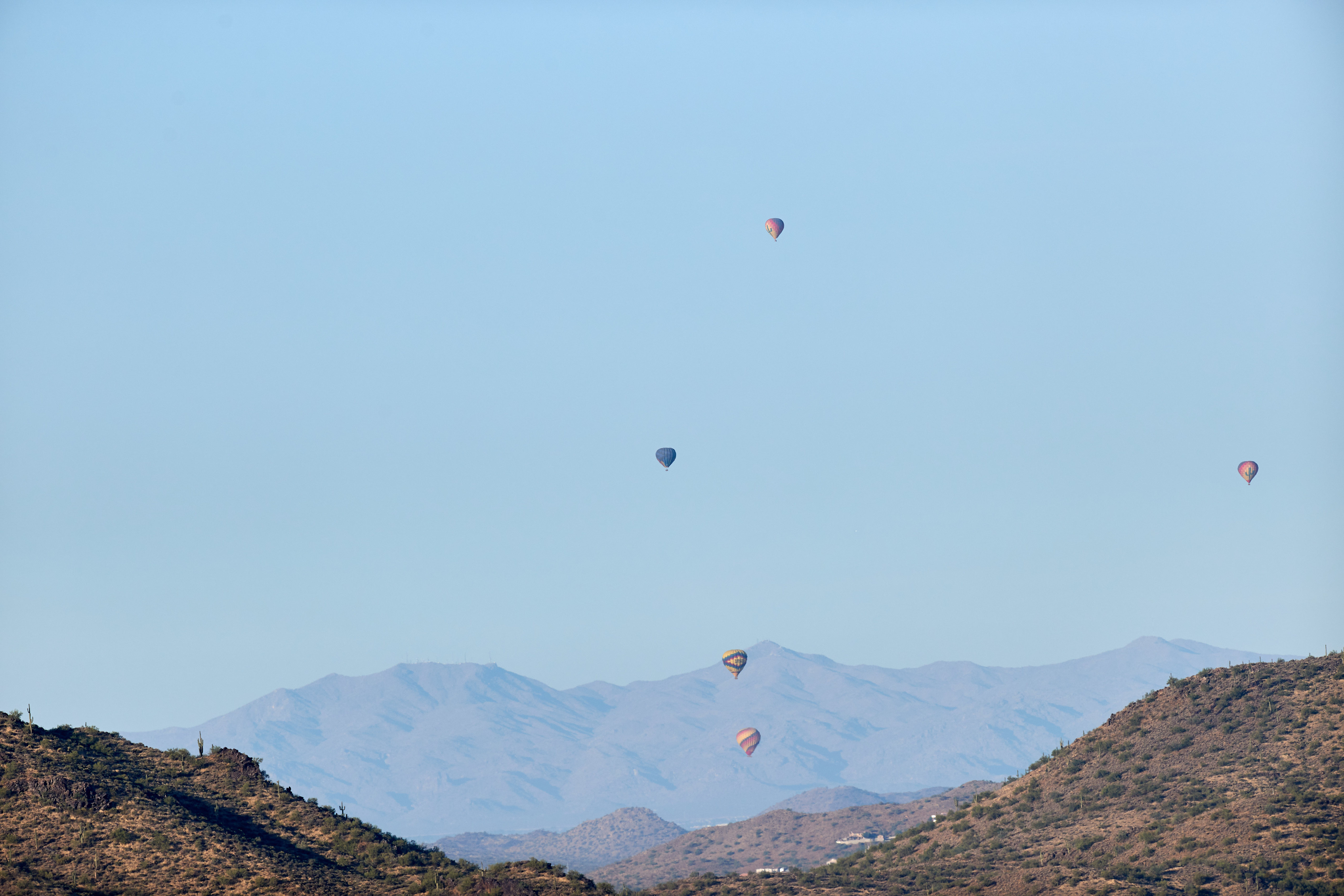 Download mobile wallpaper Rocks, Sky, Flight, Mountains, Nature, Balloons for free.